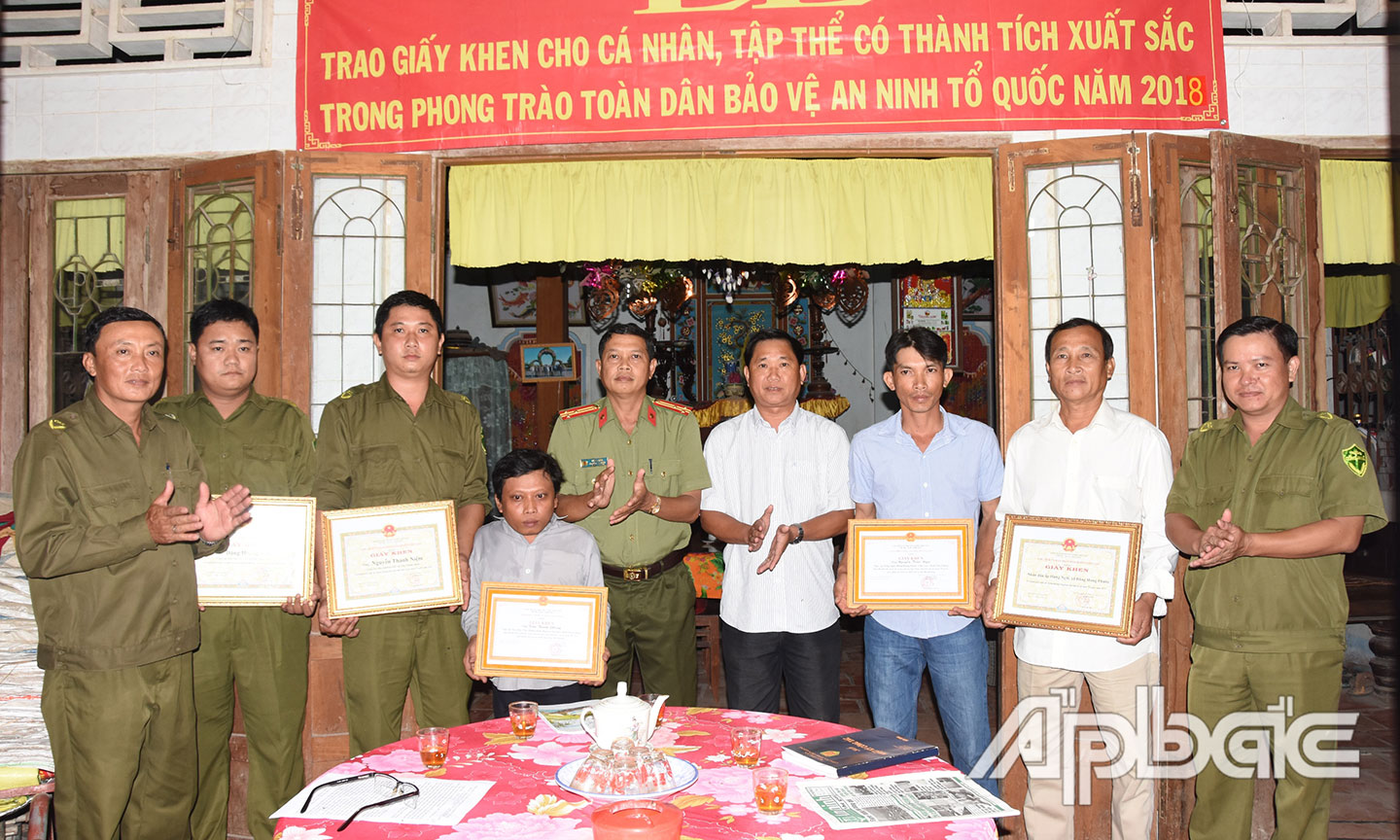 Thượng tá Lê Văn Tỉnh, Phó Trưởng Công an huyện Chợ Gạo trao Giấy khen cho các tập thể, cá nhân có thành tích xuất sắc trong phong trào TDBVANTQ năm 2018. 						             Ảnh: ĐẶNG THANH 