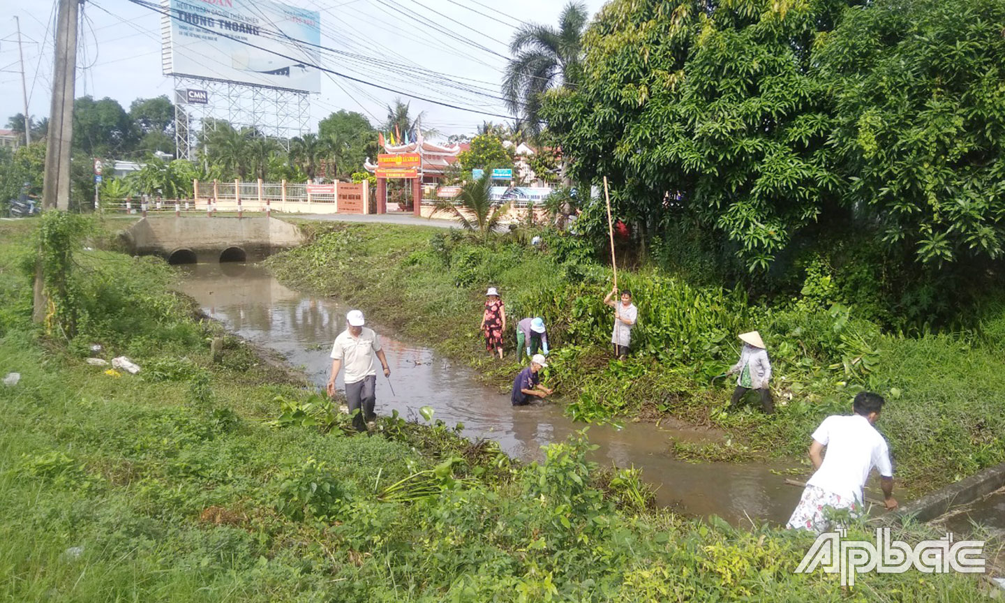 Chi hội Phụ nữ, Chi hội Nông dân, Ban Quản lý ấp Long Tường vớt lục bình trên kinh Rạch Hào khai thông dòng chảy.