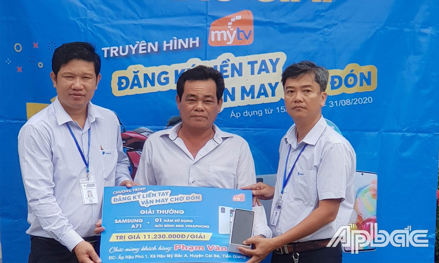 Ông Nguyễn Hoài Linh - PGD VNPT-VinaPhone Tiền Giang & Ông Võ Anh Sơn- GD VinaPhone Cái Bè trao thưởng cho khách hàng Phạm Văn Mỹ.