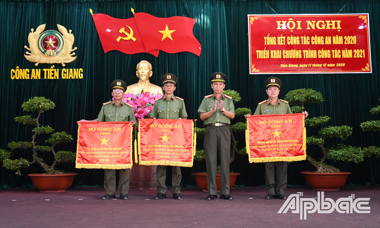 Đồng chí Đại tá Nguyễn Văn Nhựt, Ủy viên Ban Thường vụ Tỉnh ủy, Giám đốc Công an tỉnh trao cờ thi đua của Bộ Công an tặng các “đơn vị dẫn đầu phong trào thi đua cấp cơ sở”. Ảnh: Đặng Thanh.