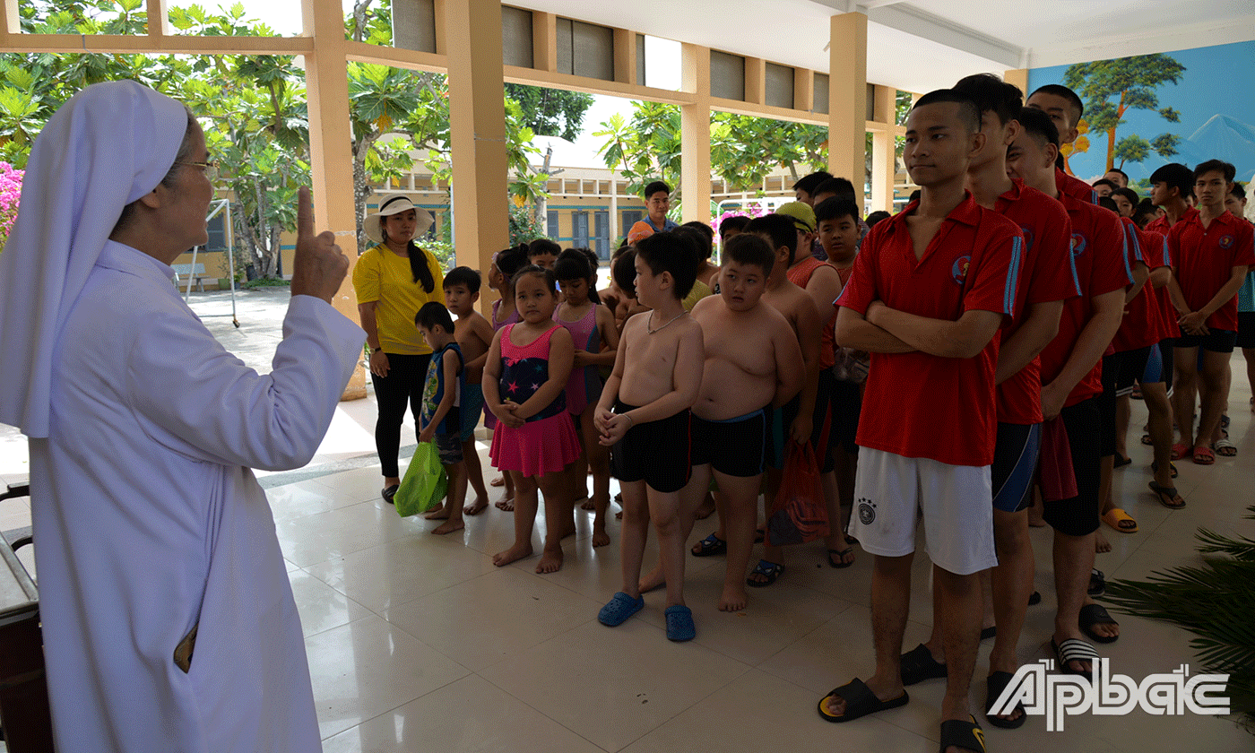 Nữ tu Elisabeth Nguyễn Thị Sương, Hiệu trưởng Trường Khuyết tật Nhân Ái căn dặn các em trước khi đi bơi tại trung tâm thể dục thể thao TP. Mỹ Tho.