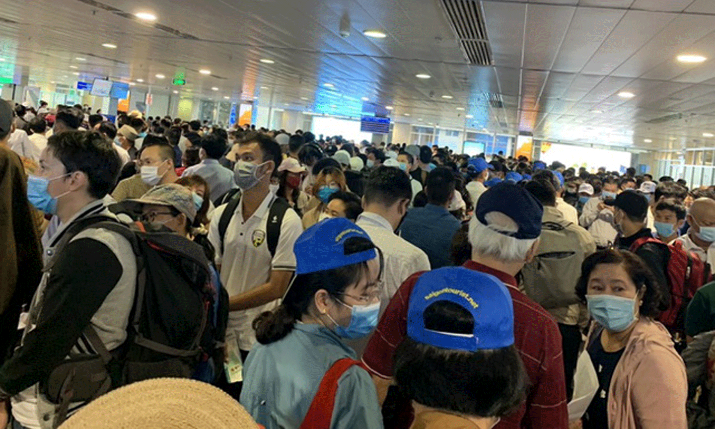 Hành khách xếp hàng dài chờ đợi qua cửa soi chiếu an ninh sân bay Tân Sơn Nhất trong sáng 15-4. Ảnh: TTXVN.