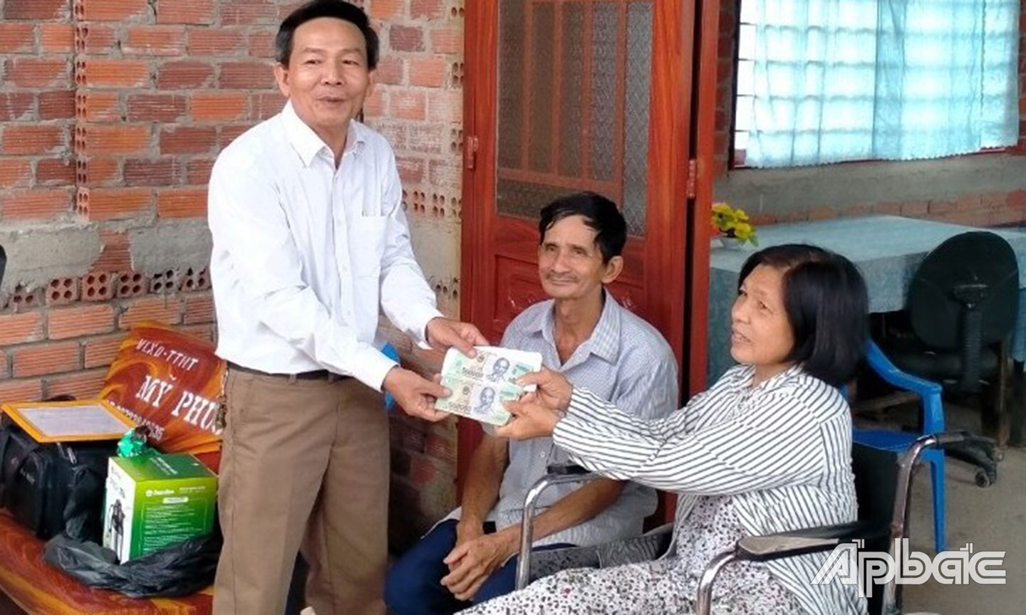 Phó Chủ tịch Hội NNCĐDC huyện Tân Phước Nguyễn Văn Tám trao tiền xây dựng “Mái ấm da cam” của nhà tài trợ cho NNCĐDC Bùi Thị Diễm Phượng ở xã Tân Hòa Tây.