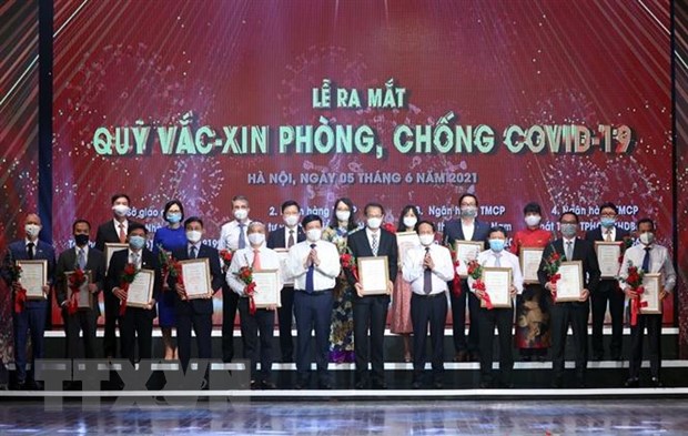 Đại diện các tập đoàn, tổng công ty, doanh nghiệp trao ủng hộ Qũy vaccine phòng COVID-19. (Ảnh: Dương Giang/TTXVN)