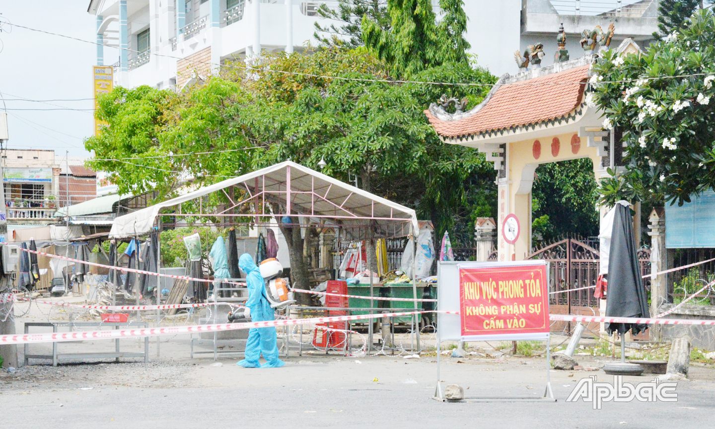 Nhân viên y tế phun khử khuẩn khu vực phong tỏa chợ Ba Dừa vào sáng 13-6. Ảnh: THỦY HÀ