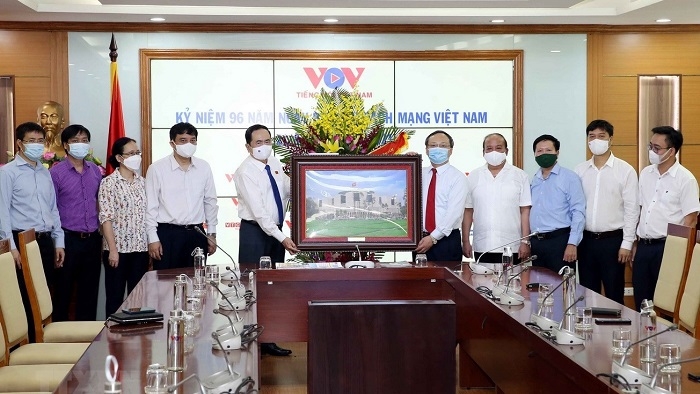 Standing Vice Chairman of the National Assembly Tran Thanh Man (L) presents a photo of the National Assembly House to the Voice of Vietnam on the 96th anniversary of Vietnam Revolutionary Press Day. (Photo: VNA).