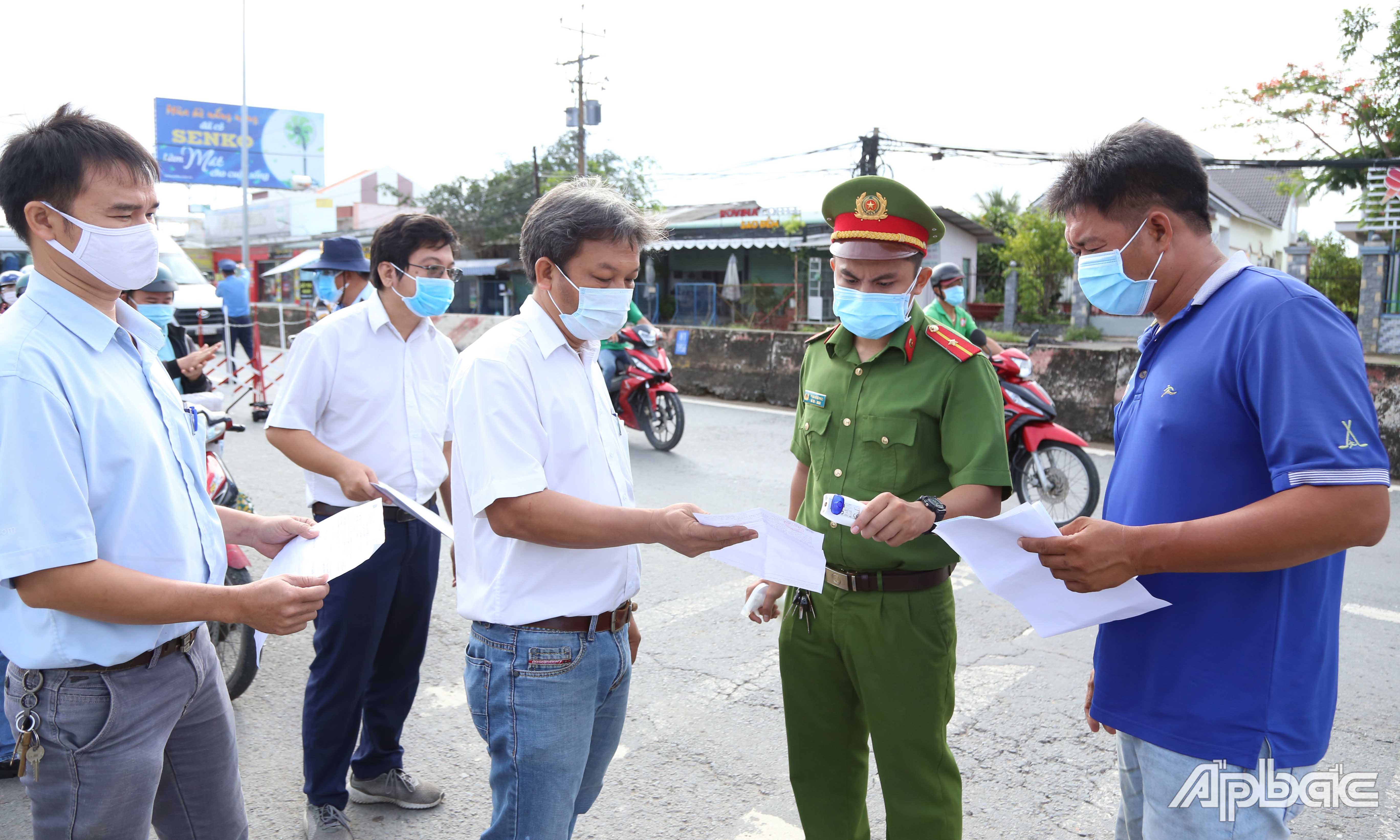 Lực lượng làm nhiệm vụ kiểm tra giấy test nhanh SARS-CoV-2 đối với các tài xế chỉ đi ngang tỉnh Tiền Giang.