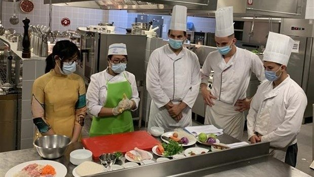 Students at the ESHRA learn to cook Vietnamese nem (fried spring rolls) (Photo: VNA).