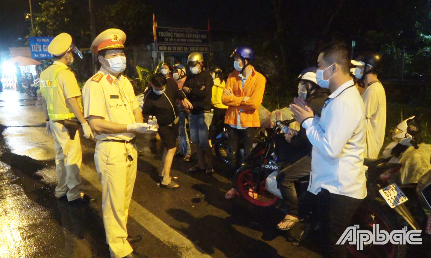 Trung tá Lê Anh Tuấn cùng đồng đội tại cửa ngõ Tiền Giang (xã Tân Hương, huyện Châu Thành) kiểm soát, xử lý tình hình người dân đổ về quê tránh dịch Covid-19.