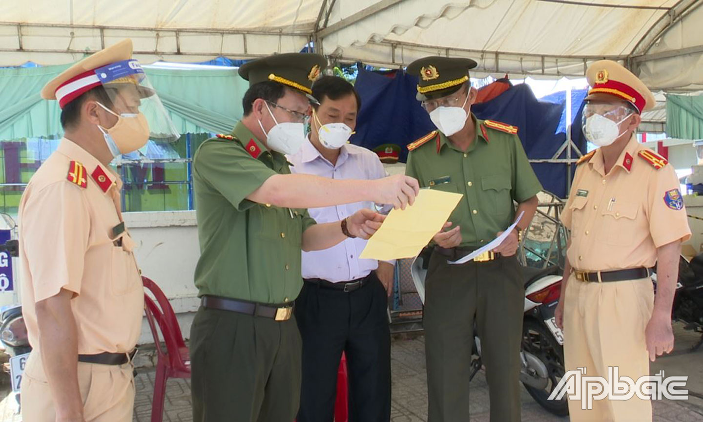 Thượng tá Nguyễn Minh Tân tham mưu, phục vụ lãnh đạo kiểm tra  công tác tại chốt kiểm soát phòng, chống dịch Covid-19.  	                                                                                                       Ảnh THANH VIỆT
