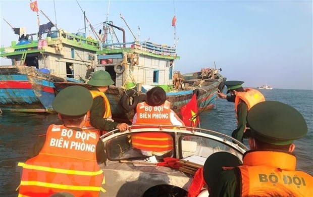 Border guards in Quang Binh province examine a fishing boat and disseminate legal regulations to fishermen. (Photo: VNA).