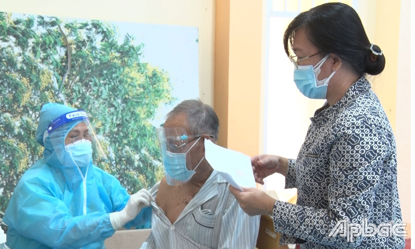 Nhân viên y tế tiêm mũi 2 vắc xin Moderna cho người trên 65 tuổi tại phường 4.