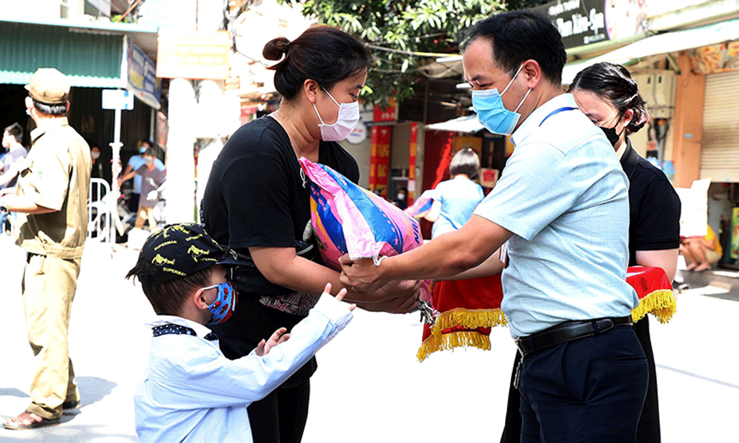 Đại diện phường Dịch Vọng Hậu, quận Cầu Giấy (Hà Nội) trao tiền hỗ trợ và nhu yếu phẩm cho người lao động trên địa bàn. Ảnh: MINH HÀ