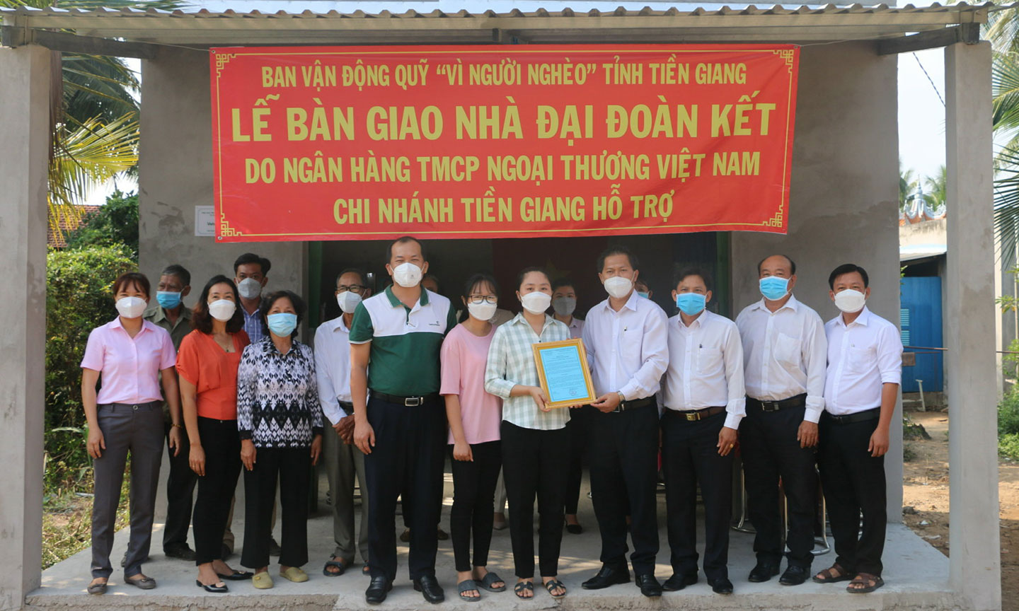 Ông Trần Đăng Khoa – Phó chủ tịch Công đoàn cơ sở, TP HCNS Vietcombank Tiền Giang (Ngoài cùng bên trái hàng đầu) trao nhà Đại đoàn kết tại huyện Chợ Gạo, Tiền Giang.