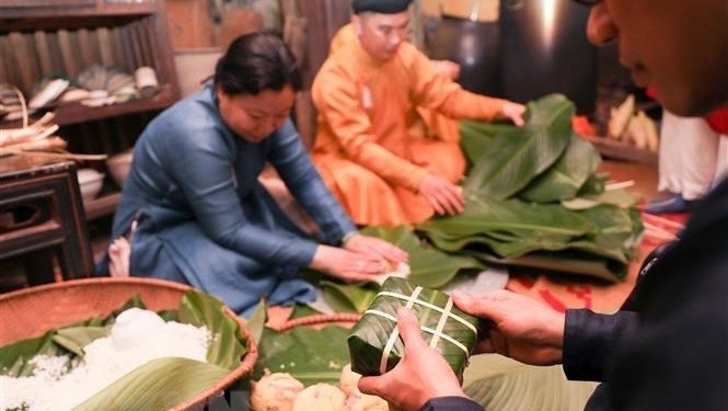 Wrapping banh chung for Tet. (Photo: VNA).