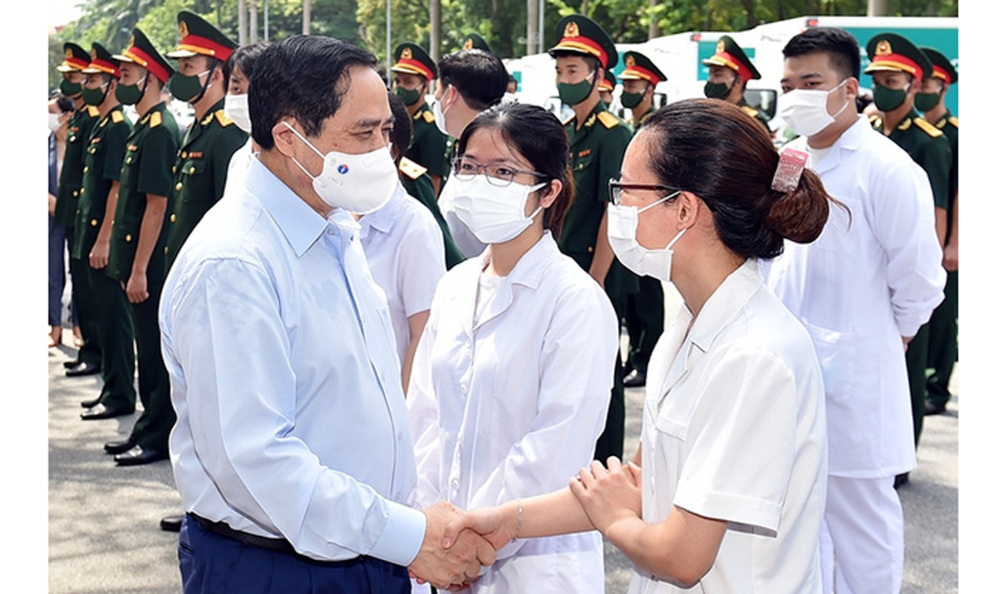Thủ tướng Phạm Minh Chính động viên các chiến sĩ áo trắng trên tuyến đầu chống dịch. Ảnh VGP/Nhật Bắc