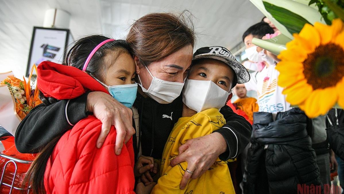 A Vietnamese citizen in Ukraine hugged her two grandchildren after arriving in Vietnam safely. (Photo: Thanh Dat).