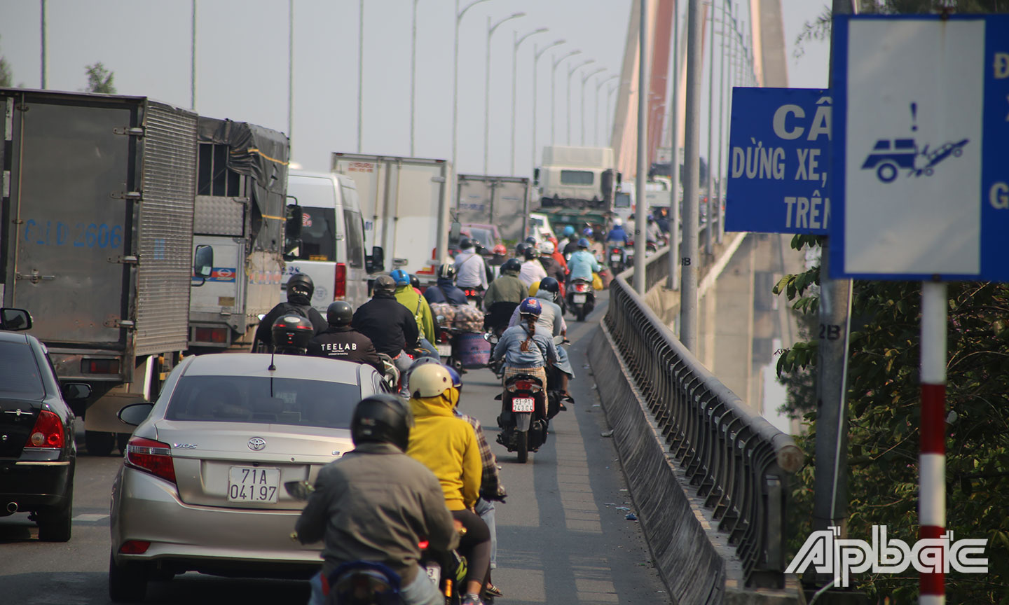 Các phương tiện ô tô rồng rắn nối đuôi nhau qua cầu Rạch Miễu.