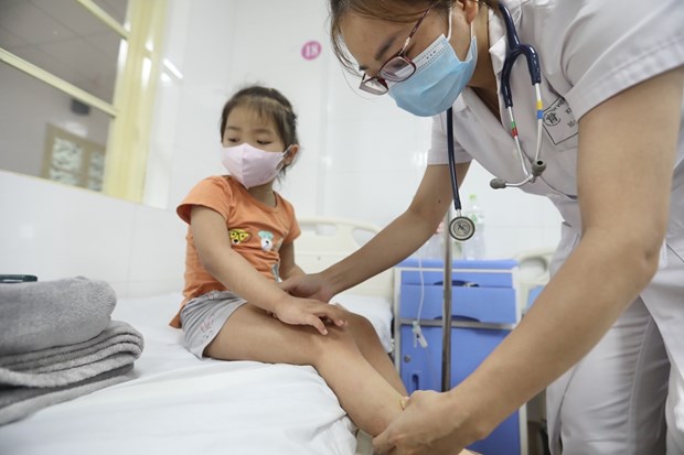 Bác sỹ khám cho bệnh nhi mắc sốt xuất huyết. (Ảnh: Minh Quyết/TTXVN)
