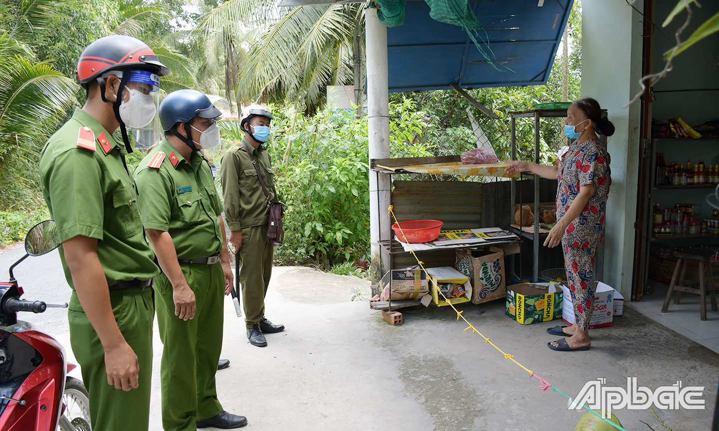 Công an xã Phú Mỹ (huyện Tân Phước) tuyên truyền phòng, chống Covid-19 cho người dân. Ảnh: THANH VIỆT