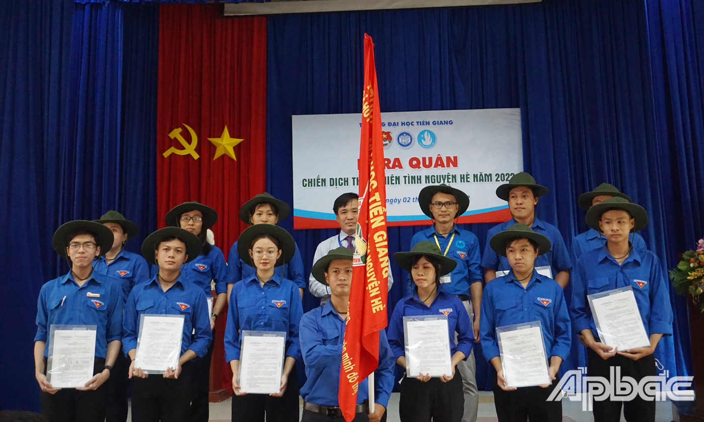 Thầy Nguyễn Hoàng Vũ, Phó Hiệu Trưởng, Chỉ huy trưởng Chiến dịch TNTN hè trường Đại học Tiền Giang năm 2022 trao cờ trước giờ ra quân