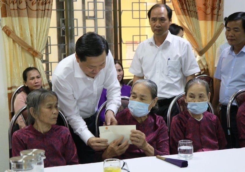 Deputy Prime Minister Le Minh Khai presents gifts to people with meritorious service to the revolution at the centre.