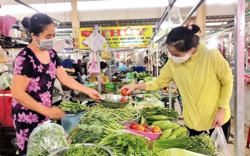 A woman shops for vegetables at a market in Ho Chi Minh City. (Photo: NDO).