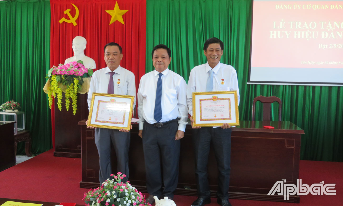 Đồng chí Trương Minh Tới, Bí thư Huyện ủy trao huy hiệu 30 năm tuổi Đảng cho đồng chí Trần Hữu Phong, đồng chí Nguyễn Văn Trầm.