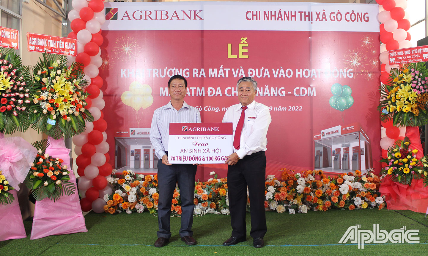 Ông Trần Phi Châu, Giám đốc Agribank Thị xã Cò Công (bên phải), trao biển tượng trưng số tiền và gạo cho Ông Phạm Thanh Nguyên,Ủy viên Ban Thường vụ Thị ủy, Trưởng Ban Dân vận, Chủ tịch Ủy ban MTTQ Việt nam Thị xã Gò Công.