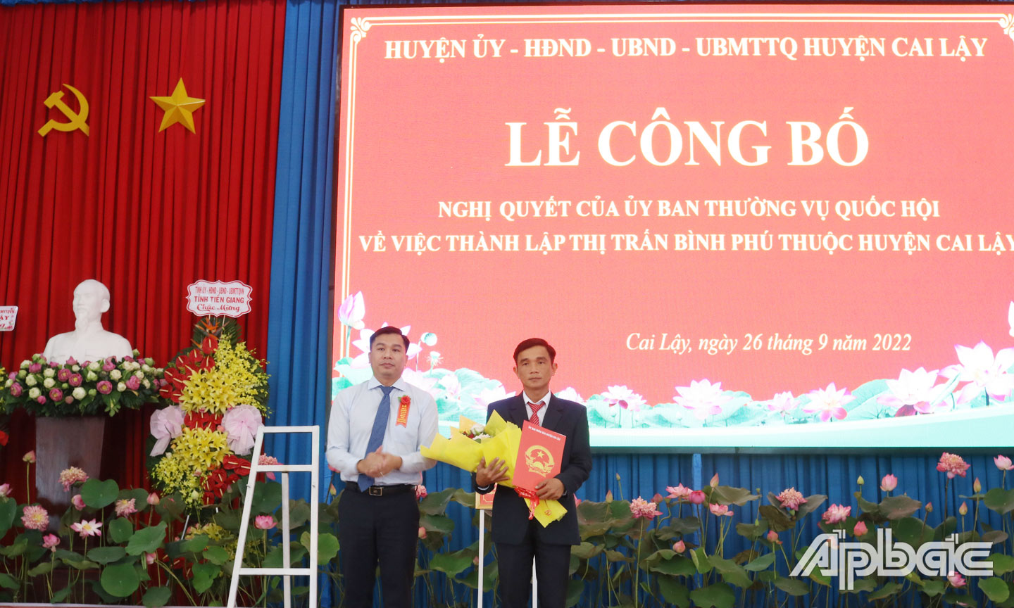Ông Trần Quốc Bình, Phó Bí thư Huyện ủy, Chủ tịch UBND huyện Cai Lậy trao Quyết định số 2603 về chuyển nguyên trạng 11 ấp thành khu 11 phố thuộc thị trấn Bình Phú, huyện Cai Lậy, tỉnh Tiền Giang.