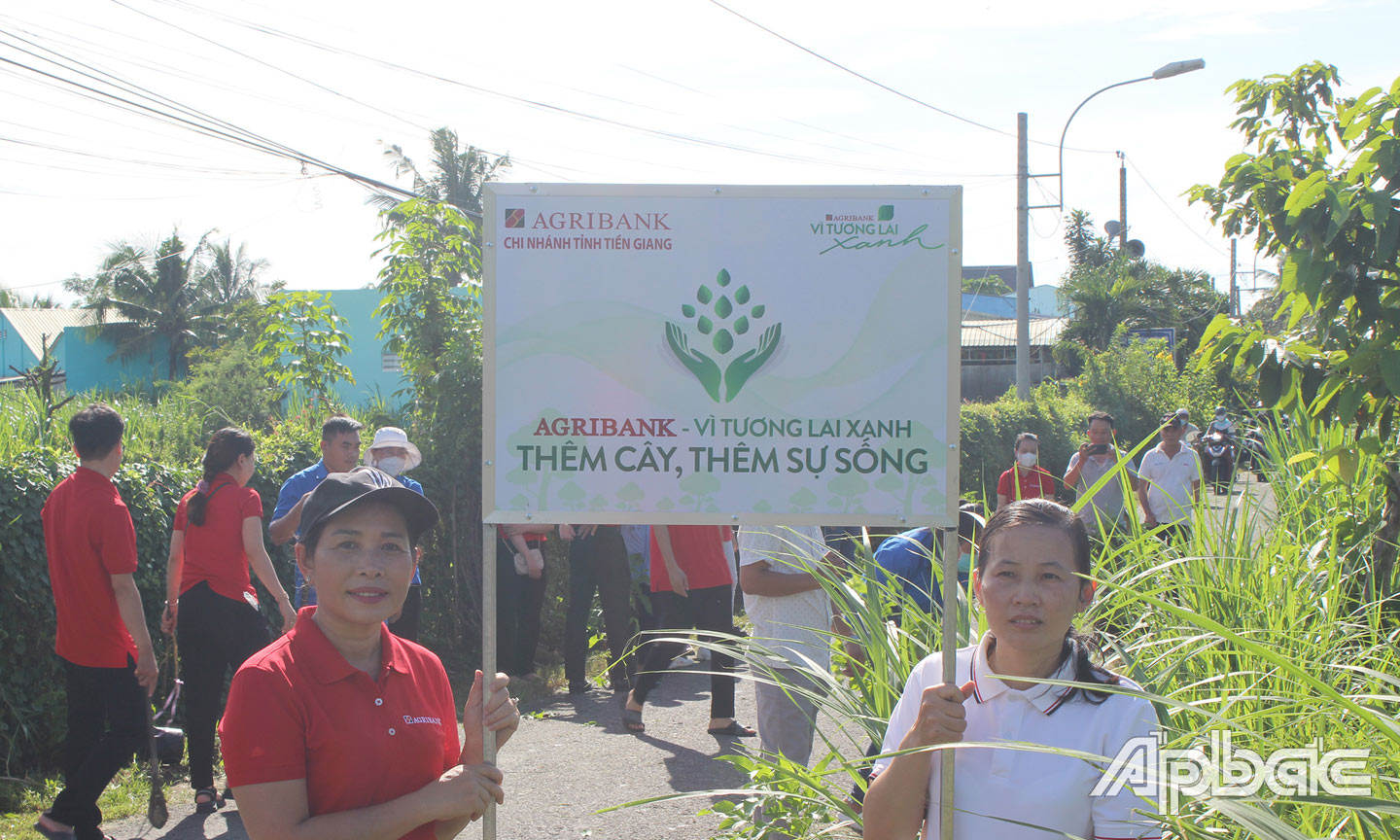 Phó Chủ tịch CĐCS Agribank Tiền Giang (bên trái) và Bà Nguyễn Thị Hồng Nhung, Phó chủ tịch UBND xã Mỹ phong cùng gắn biển Tuyến đường “Agribank - Vì tương lai xanh” 