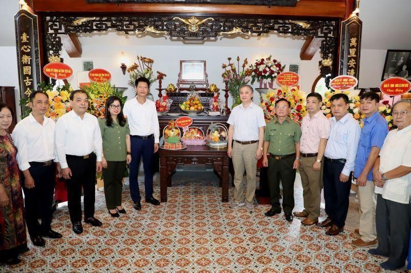 Delegates and family members take souvenir photos at the memorial house dedicated to Colonel Dao Dinh Bang.