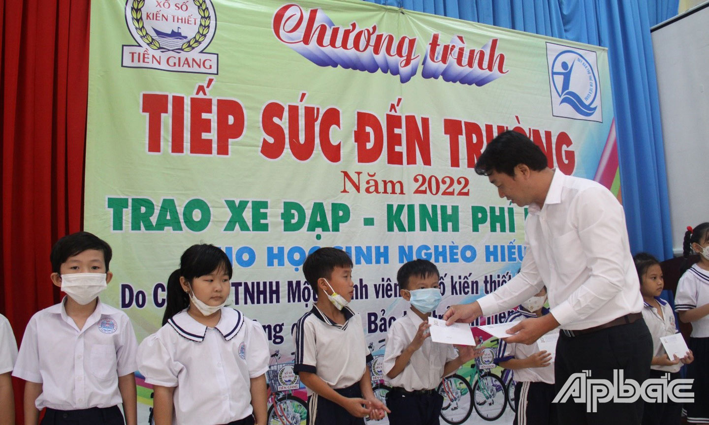 Ông Trần Văn Giang, Phó Giám đốc, Phó Chủ tịch Công đoàn cơ sở Công ty Xổ số kiến thiết Tiền Giang trao quà cho các em học sinh có hoàn cảnh khó khăn.