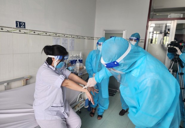 Lãnh đạo Cục Y tế dự phòng thăm hỏi, động viên người bệnh mắc đậu mùa khỉ đầu tiên tại Việt Nam. (Ảnh: TTXVN phát)
