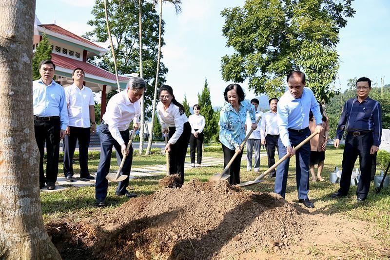 The delegates plant a souvenir tree at the relic of the Party Central Committee’s Organisation Commission in Tan Lap village.