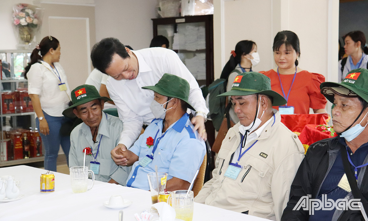 Phó Chủ tịch UBND tỉnh Nguyễn Thành Diệu cài hoa và tặng quà cho người có công trước khi tham quan thủ đô Hà Nội.