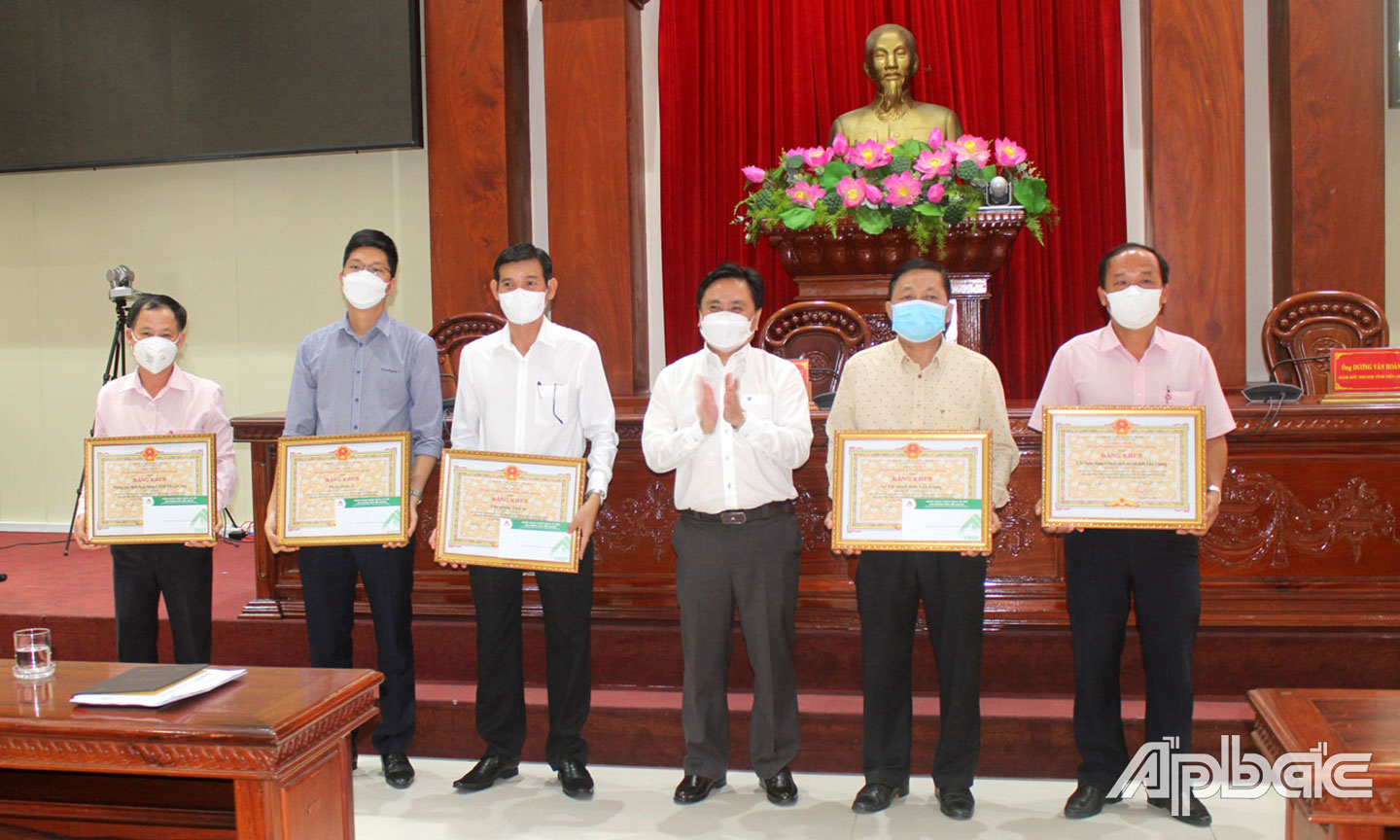 Ngân hàng CSXH Chi nhánh tỉnh Tiền Giang (bìa phải) nhận Bằng khen của UBND tỉnh Tiền Giang vì có thành tích đóng góp trong hoạt động tín dụng chính sách năm 2021.