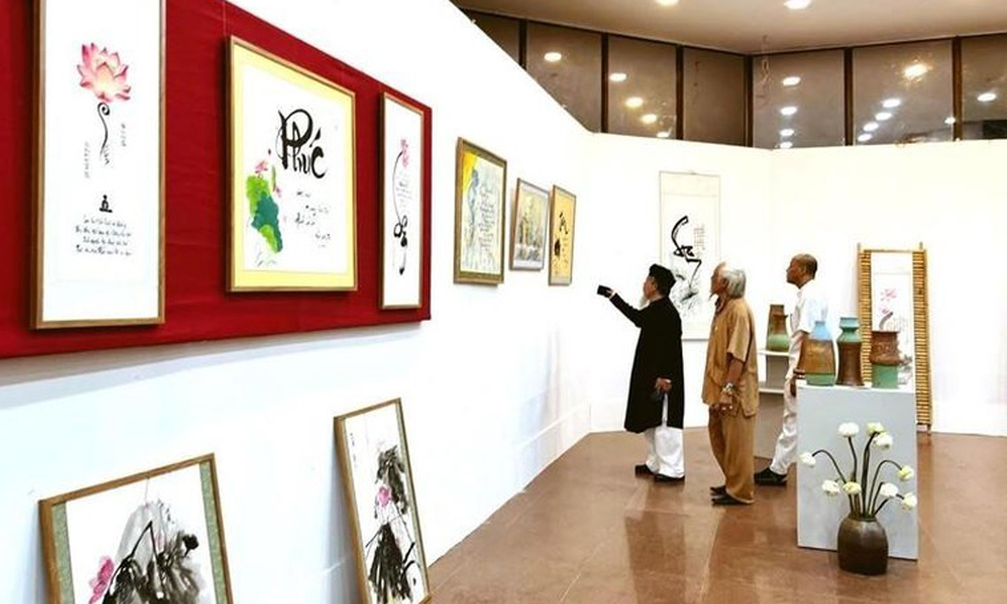 Visitors admire calligraphic works on the lotus on display at the art space.