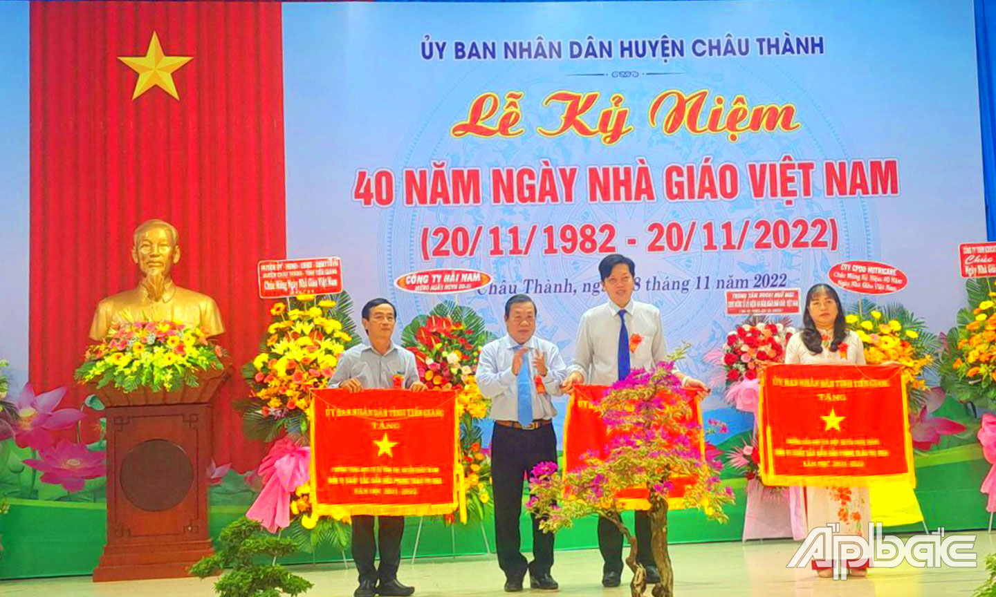 Đồng chí Nguyễn Ngọc Trầm, Ủy viên Ban Thường vụ, Chủ nhiệm Ủy ban Kiểm tra Tỉnh ủy trao Cờ thi đua của UBND tỉnh Tiền Giang cho  Trường THCS Vĩnh Kim (bìa trái).