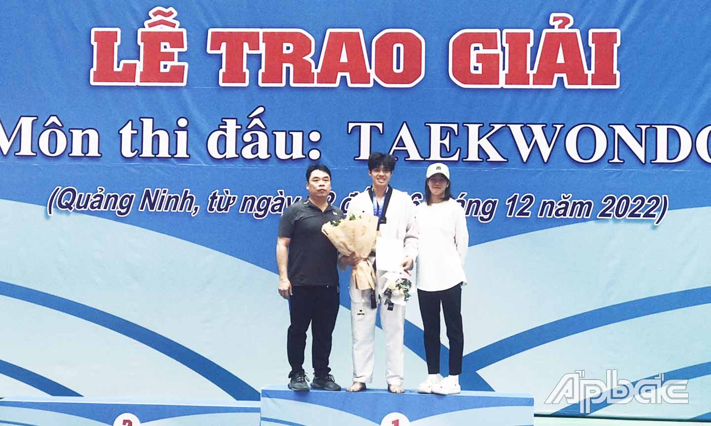 HLV Trưởng Đội Taekwondo Tiền Giang Lê Huy Hoàng (bên trái) chúc mừng VĐV Phạm Minh Bảo Kha.