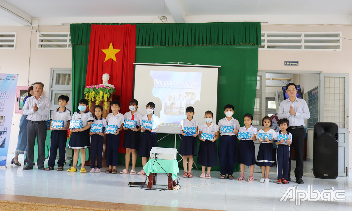 Đại diện Ngần hàng Bản Việt trao tặng quà cho các em học sinh có hoàn cảnh khó khăn.