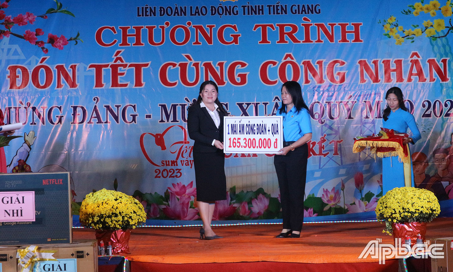 Đại diện Công ty TNHH Phát triển hạ tầng KCN Long Giang trao Bảng tượng trưng tặng “Mái ấm CĐ” và quà cho CNLĐ tại Chương trình “Đón tết cùng công nhân - Mừng Đảng,  mừng Xuân Quý Mão 2023”  ở KCN Long Giang.