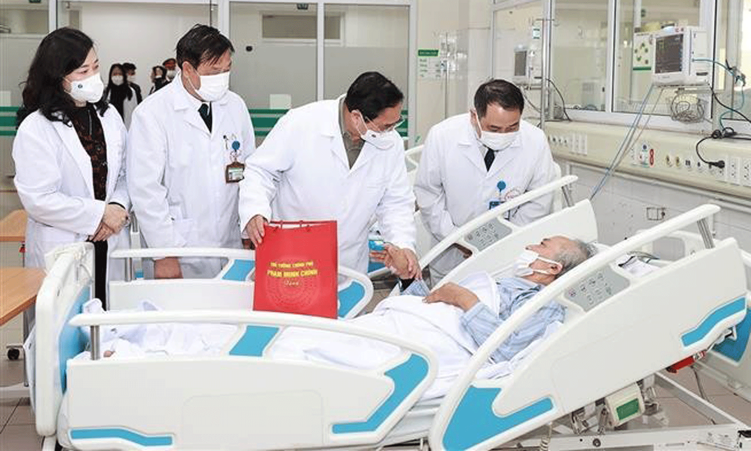 Prime Minister Pham Minh Chinh presents gift to a patient at National Hospital for Tropical Diseases. (Photo: VNA).