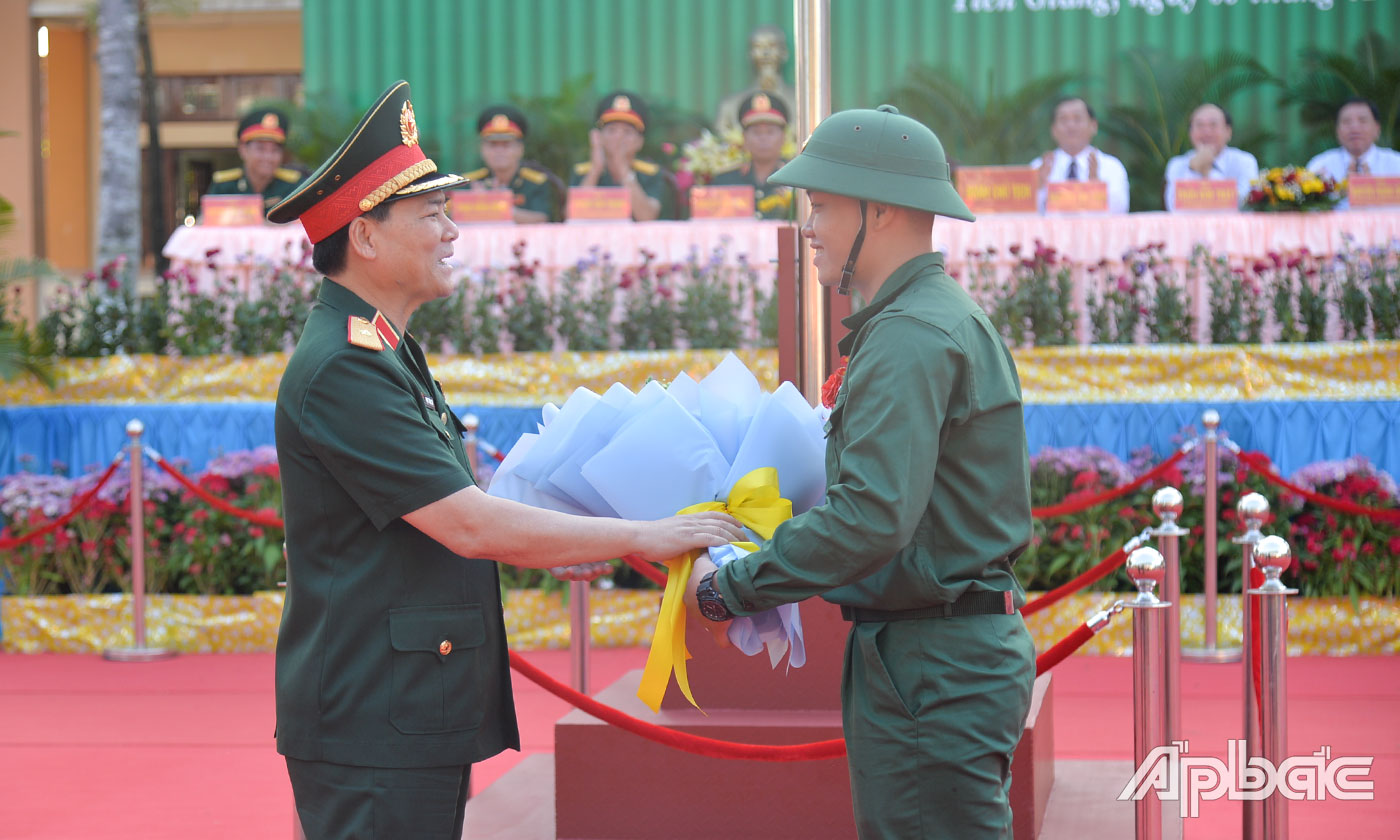 Thiếu tướng Phạm Trường Sơn tặng hoa cho thanh niên Nguyễn Nhựt Minh Đăng, đại diện 159 thanh niên TP. Mỹ Tho lên đường nhập ngũ.