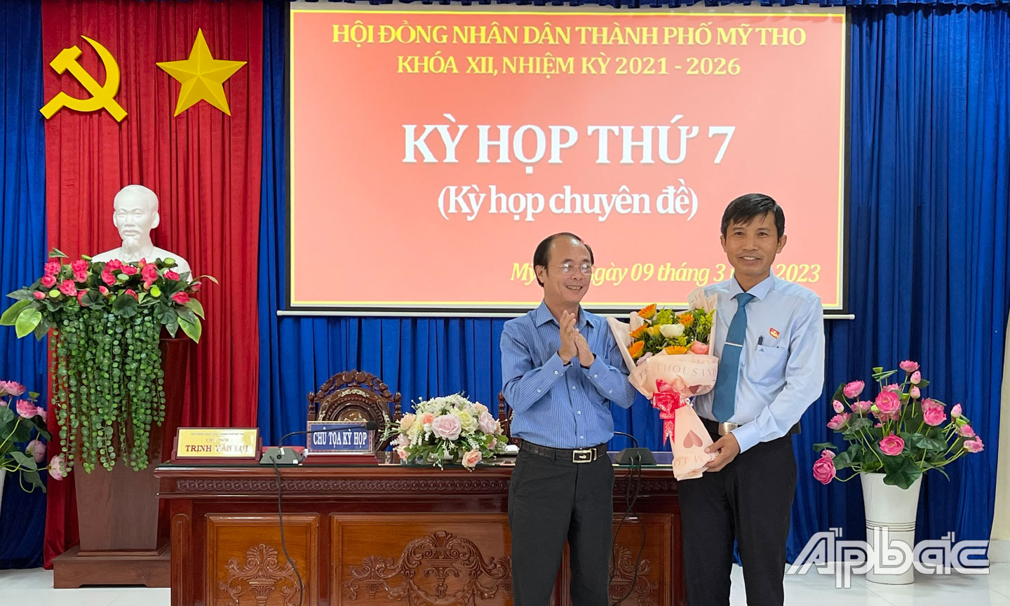 Ông Trần Kim Trát, Ủy viên Ban Thường vụ Tỉnh ủy, Bí thư Thành ủy Mỹ Tho tặng hoa chúc mừng ông Trịnh Văn Lợi.