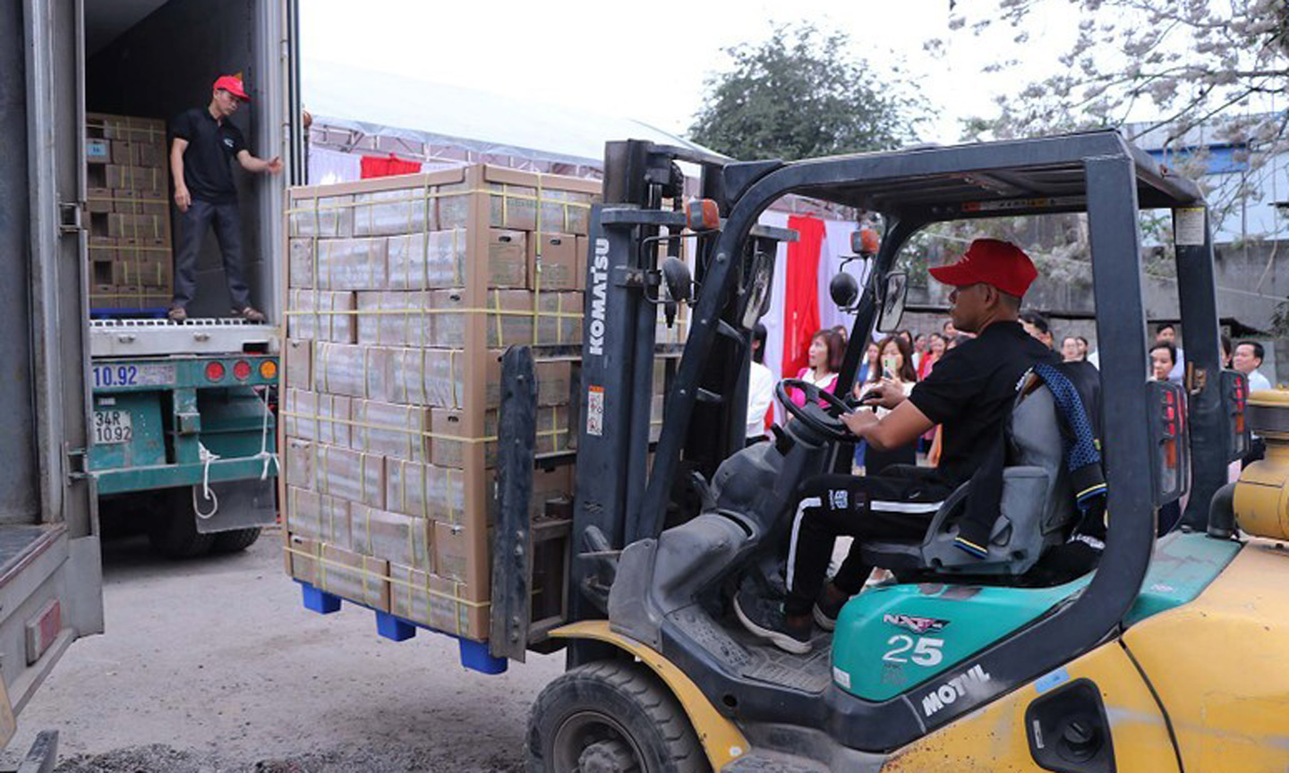 Sugarcane is loaded into a container truck for export.