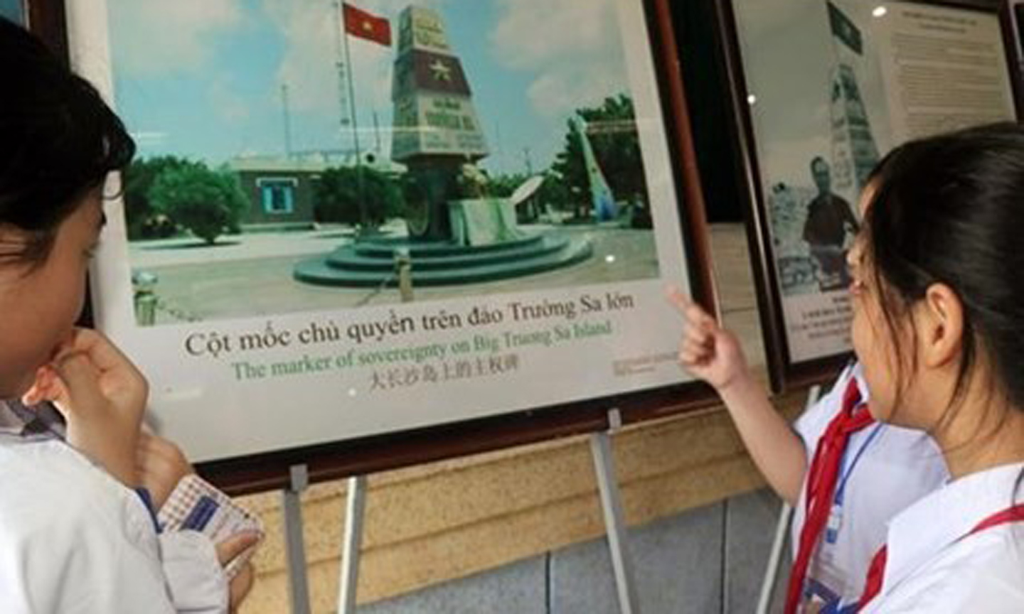 Students look at a photo displayed at the exhition. (Photo: VNA).