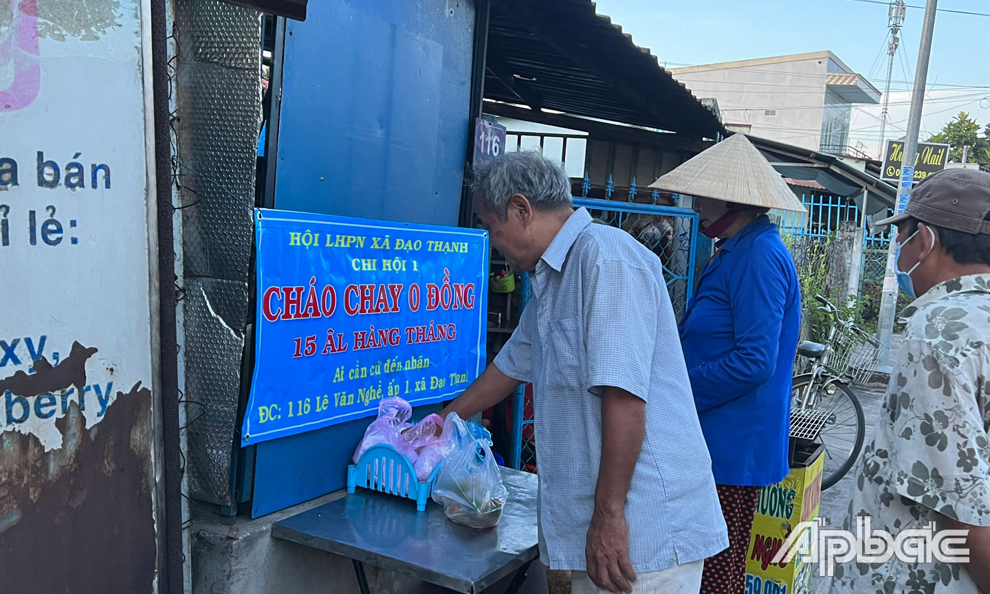 Các cô, chị phát cháo cho những người có hoàn cảnh khó khăn.
