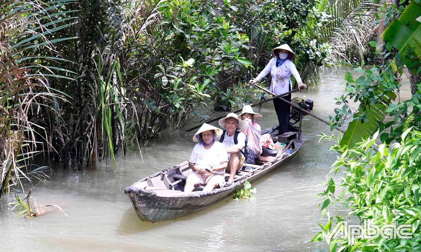 Du khách trải nghiệm đi đò chèo trên các con kinh rợp bóng dừa nước của cù lao Tân Phong.