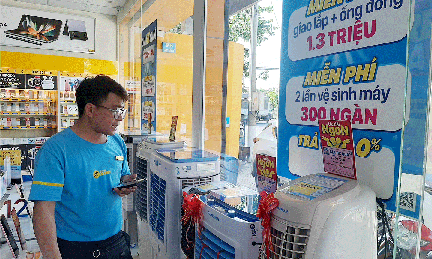 Nhân viên tại một cửa hàng điện máy đang tư vấn quạt hơi nước cho khách hàng